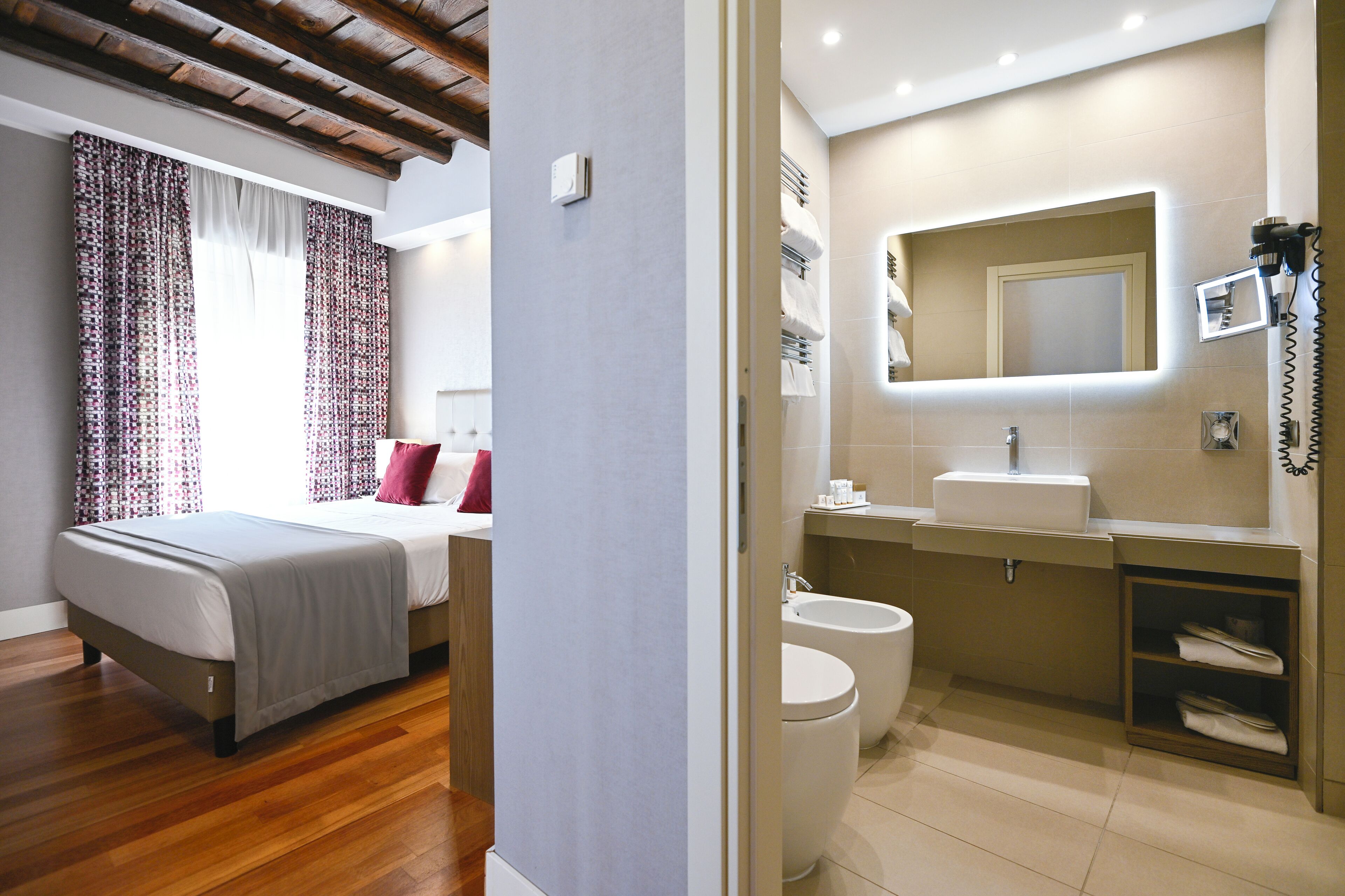 Une chambre d’hôtel moderne, équipée d’un lit, d’une salle de bain avec un lavabo et d’un miroir.