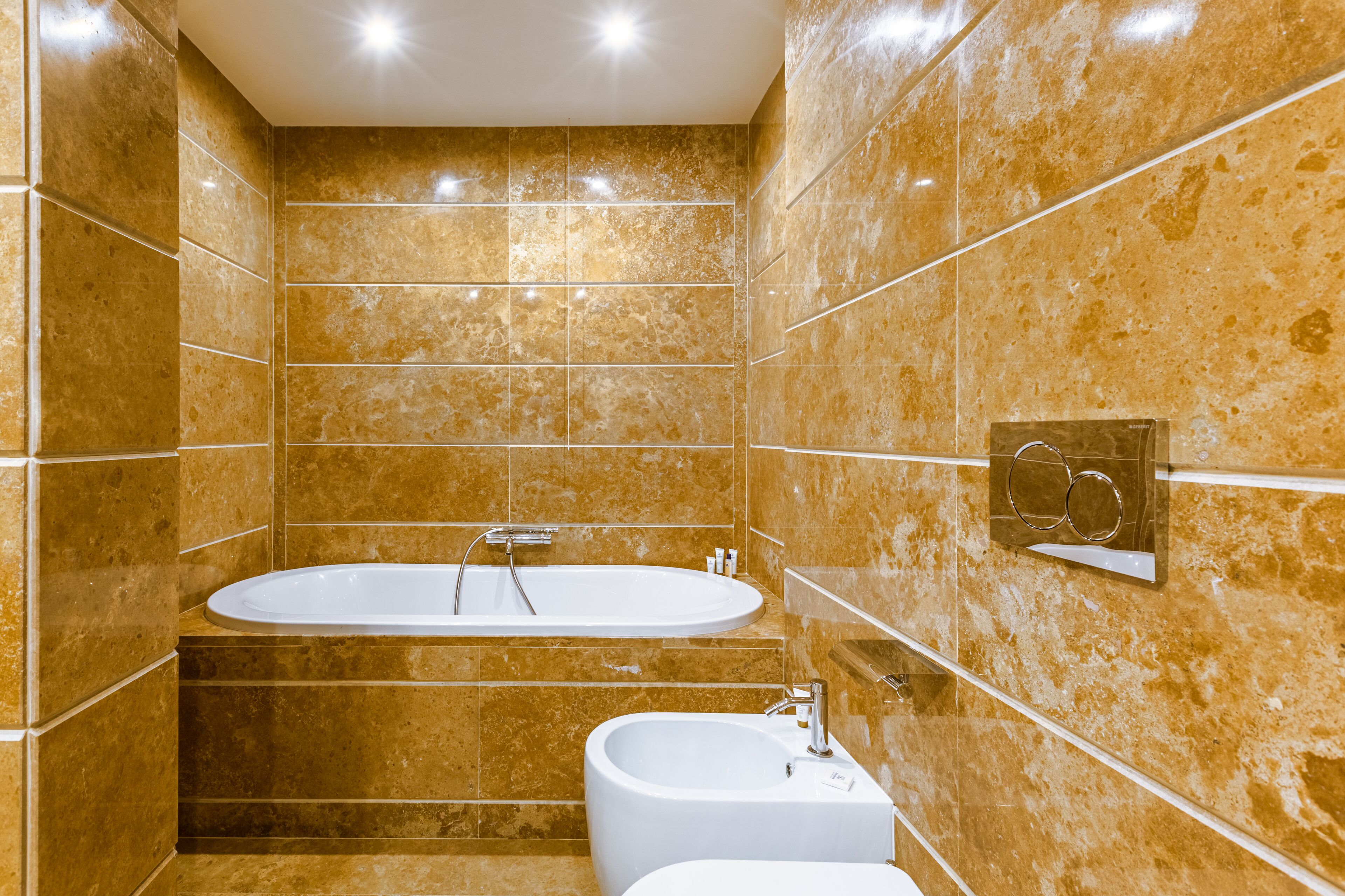 A bathroom with a bathtub, a sink, and a mirror with a towel rack.