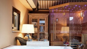 A spa area with a hot tub, wooden cabinets, and a glass-enclosed shower. - Hotel Barocco (Rome)
