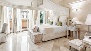 A spacious bedroom with a large bed, a canopy, and a view of buildings through large windows. - Hotel Barocco (Rome)