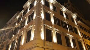 A multi-story building with classical architectural features, including columns and decorative moldings. - Hotel Barocco (Rome)
