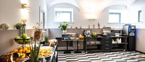 A modern kitchen with a checkered floor, a buffet with various food items, and a coffee machine.
