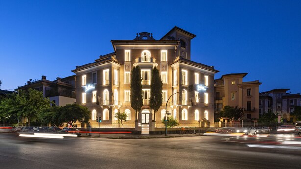 Um edifício histórico com arquitetura cl ássica, com janelas em arco e entrada central.