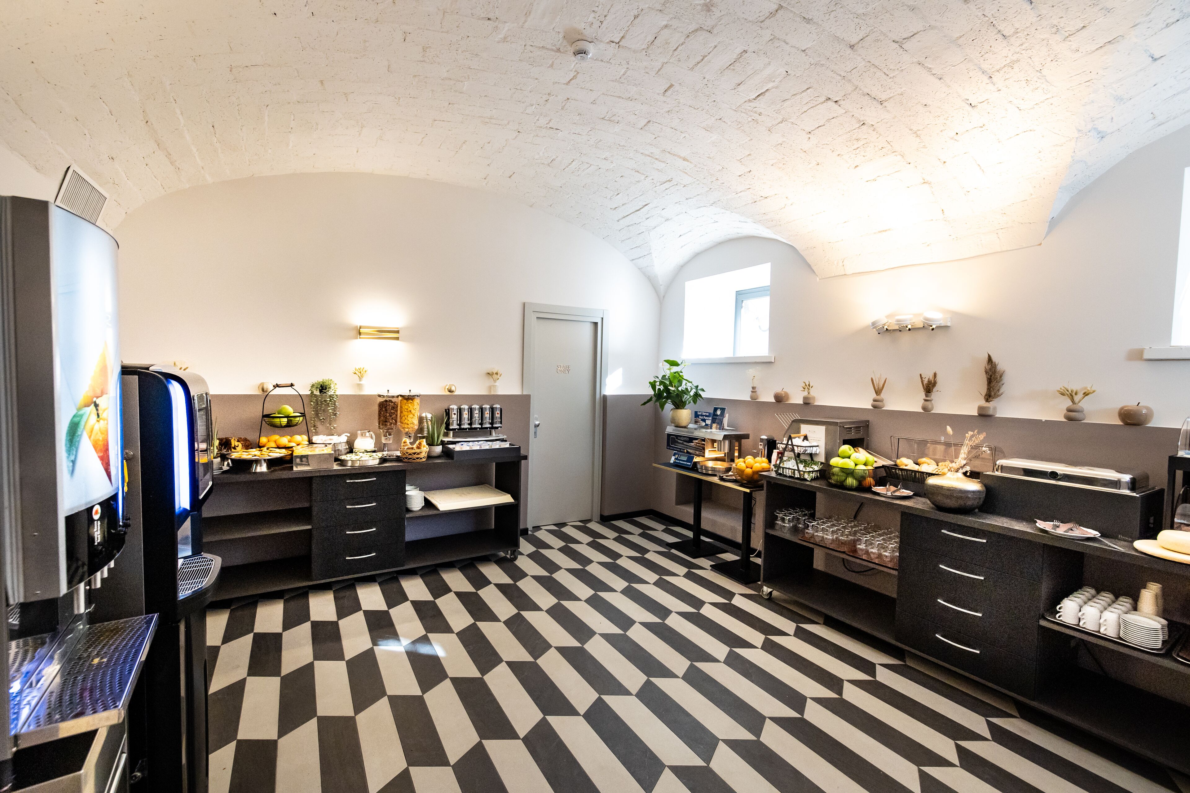 Una cocina moderna con piso a cuadros, un refrigerador, un microondas y una cafetera.
