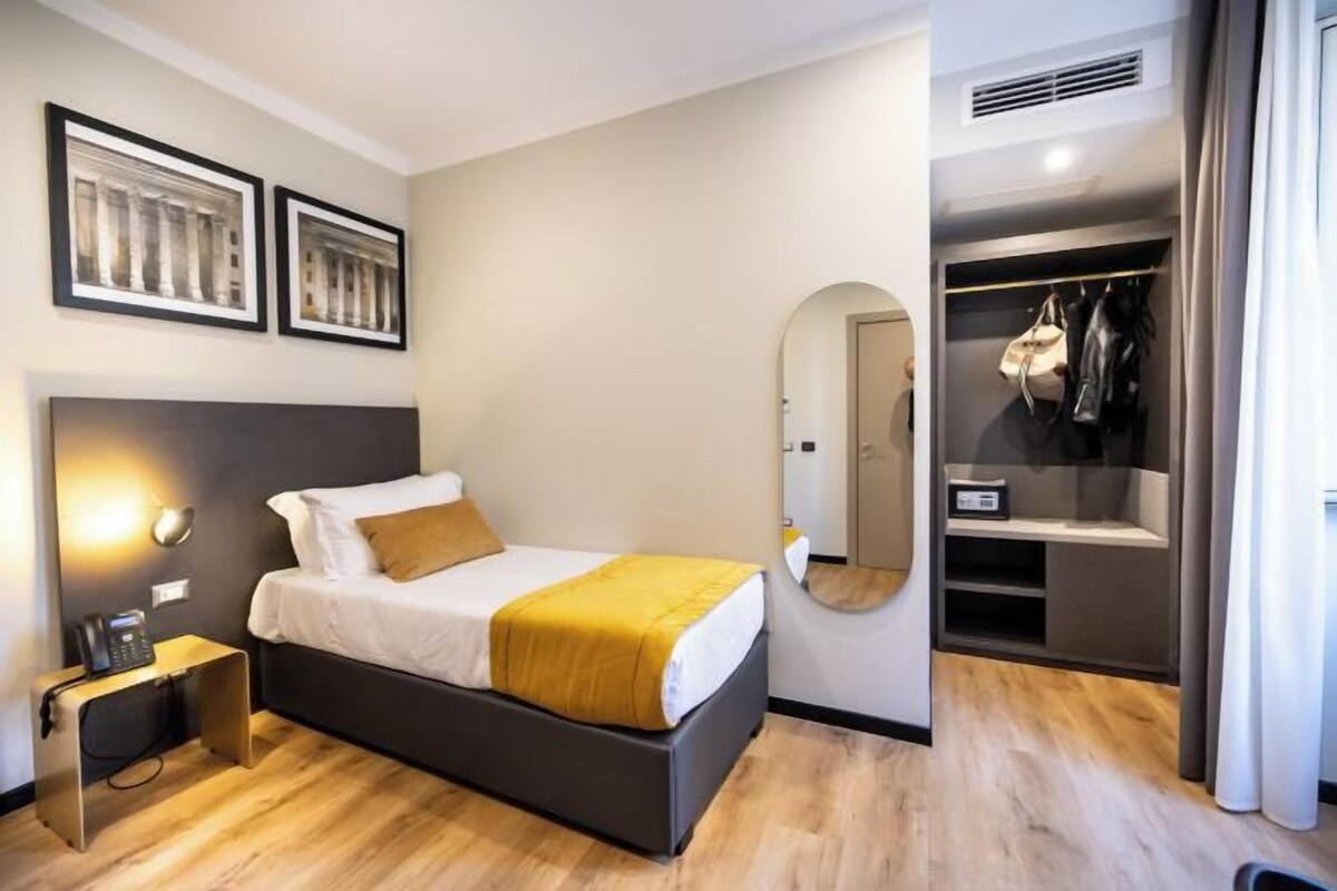 Une chambre à coucher avec un lit, une table de chevet et une armoire.