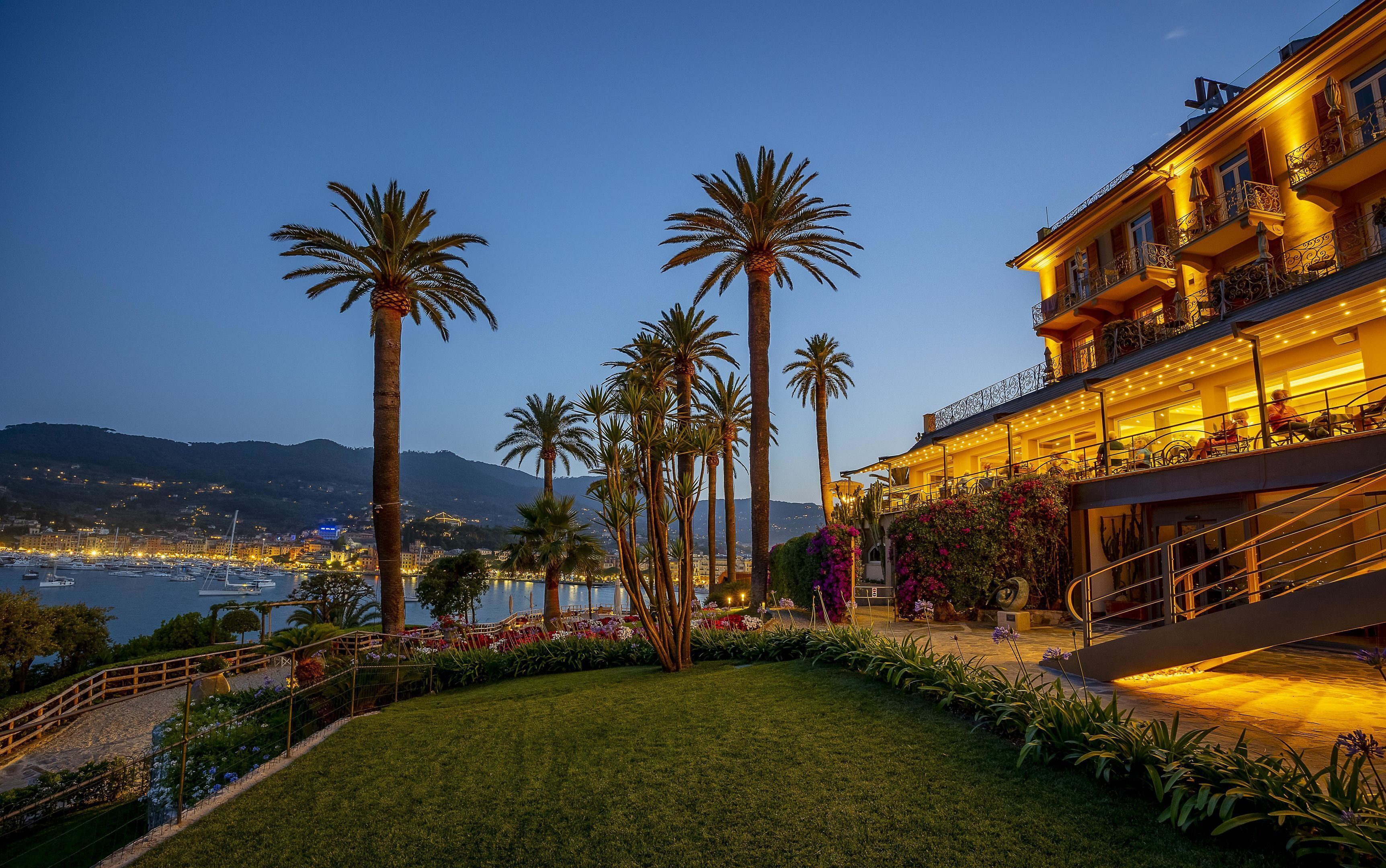 Ein gut beleuchtetes Hotel mit Blick auf Meer und Berge.