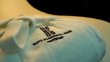 Una bolsa blanca con texto bordado y cordón.