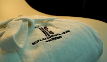 Una bolsa blanca con texto bordado y cordón.