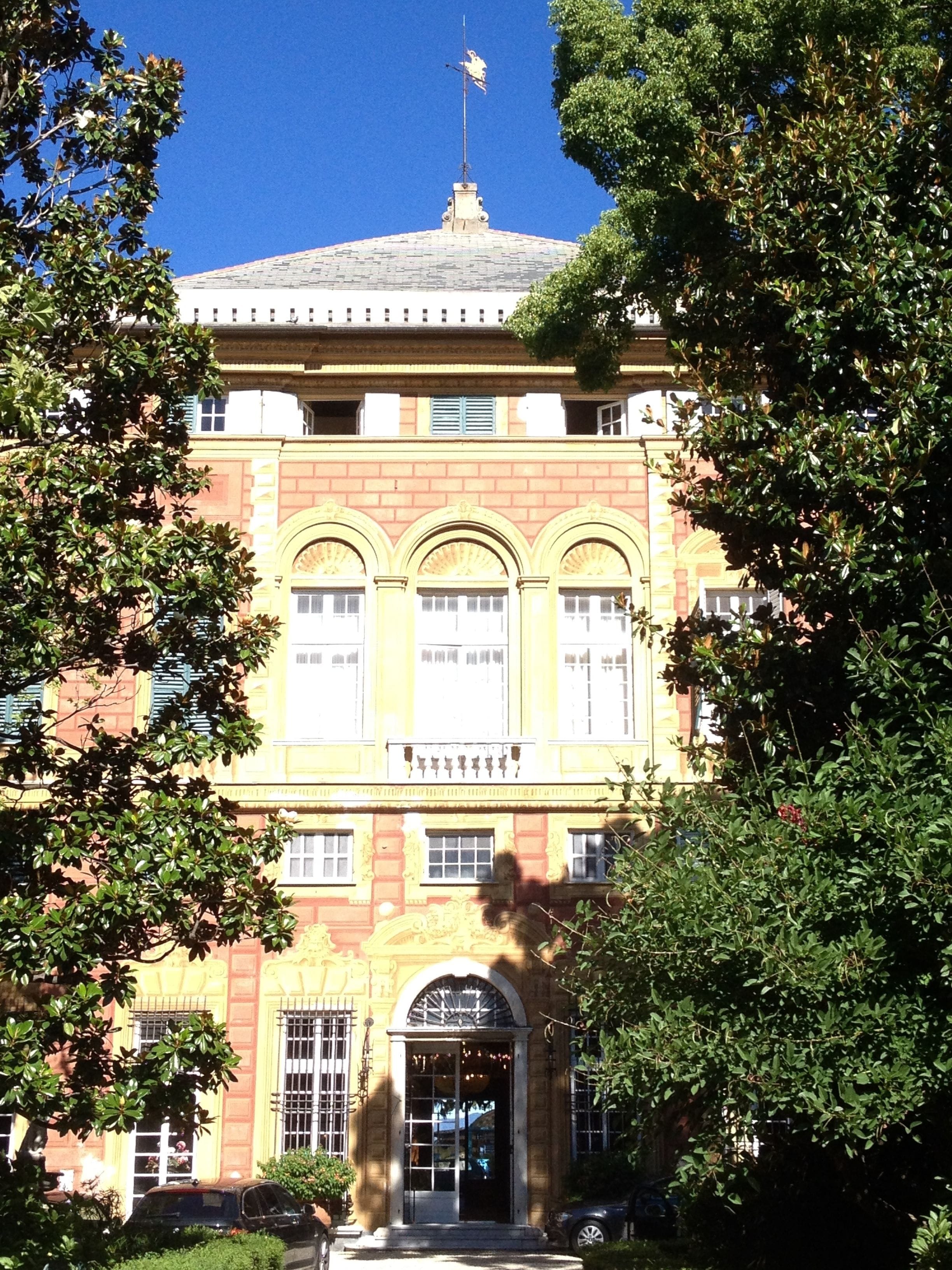 A large, historic building with a symmetrical facade, arched windows, and a central entrance with a decorative archway.