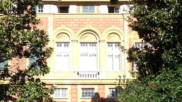 A large, historic building with a symmetrical facade, arched windows, and a central entrance with a decorative archway.