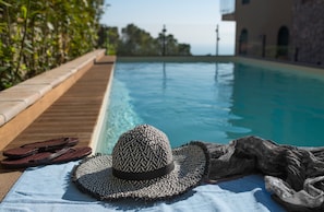 Una piscina al aire libre, sillones reclinables de piscina