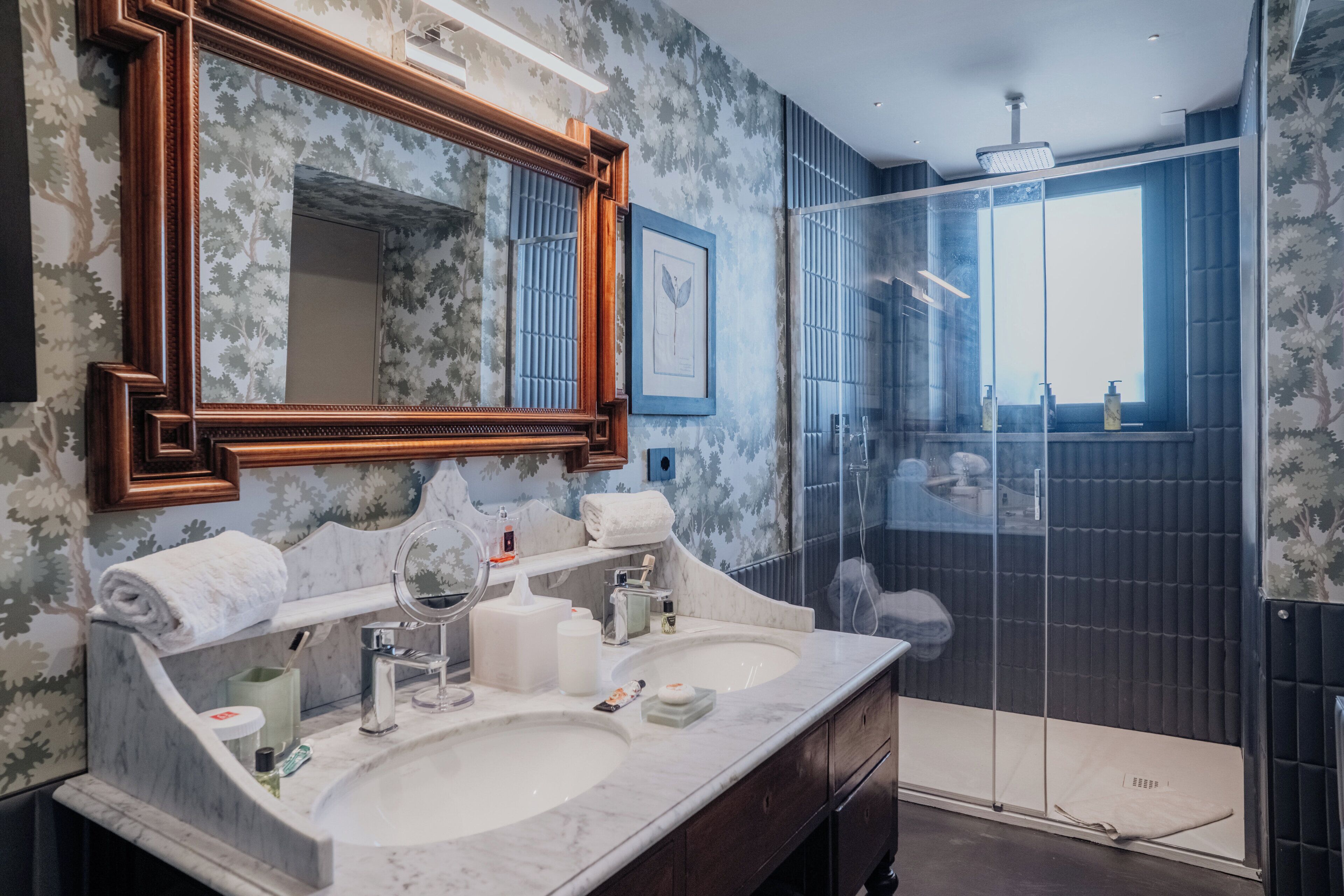 Un bagno con due lavandini, uno specchio grande e una zona doccia.