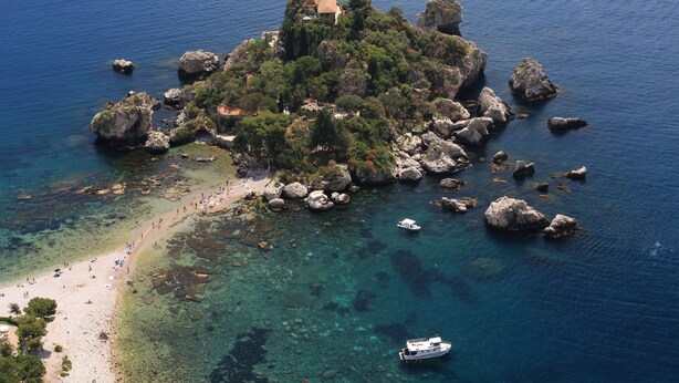 An aerial view of a rocky island with clear waters, a beach, and a small building. - Hotel Villa Ducale (Taormina)