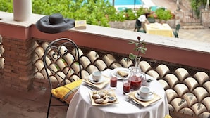 Una mesa lista para el desayuno con vista a una piscina y follaje.