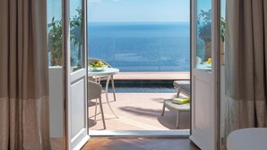 A room with a view of the sea, a small table with chairs, and a pool. - San Domenico Palace, Taormina, A Four Seasons Hotel (Taormina)