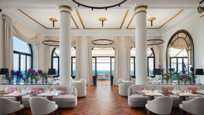 A spacious hotel lobby with high ceilings, large columns, and a view of the sea. - San Domenico Palace, Taormina, A Four Seasons Hotel (Taormina)