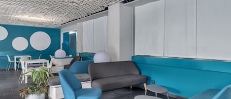 Um interior moderno com teto geométrico, paredes verde-turquesa e móveis contemporâneos.