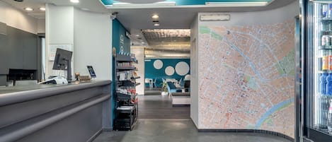Un'area reception moderna con una mappa appesa al muro, una scrivania della reception e un'area salotto sullo sfondo.