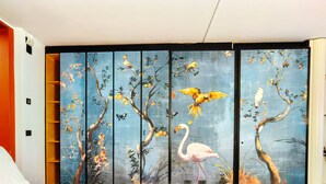 A room with a large sliding door featuring a nature-themed painting of birds and trees. - Hotel Ancora (Verbania)