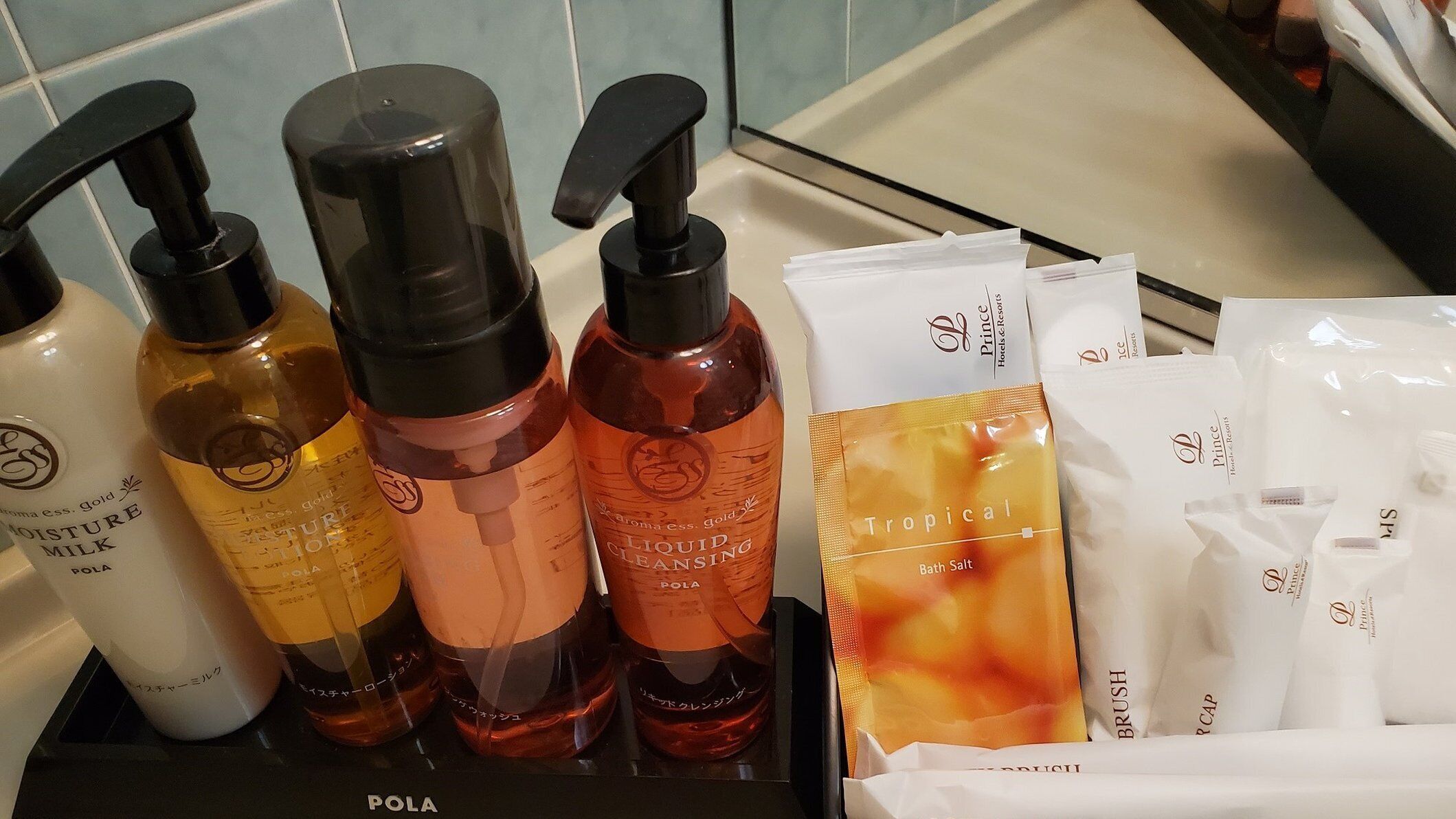 Presentación de diversos artículos de tocador, incluyendo botellas de limpiador líquido y sales de baño, junto con algunos productos envasados.