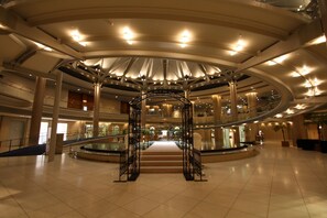 Un amplio atrio con una escalera central, varios niveles y un diseño arquitectónico moderno.