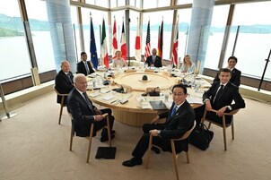 A round table with flags, a view of a lake, and a modern interior.
