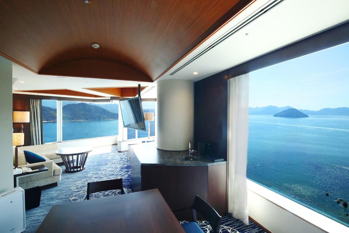 Una habitación moderna con un ventanal grande, una mesa de comedor y un televisor.
