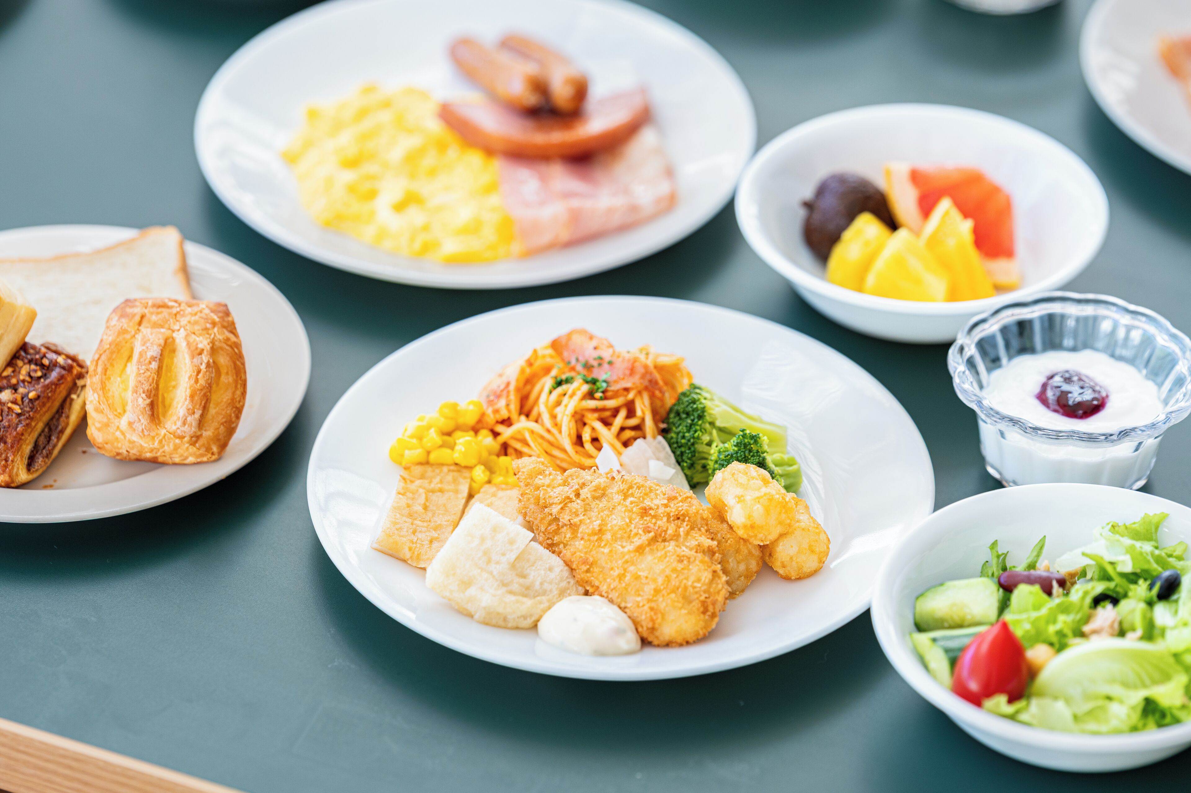 A variety of breakfast dishes including eggs, sausages, toast, and vegetables on a table.
