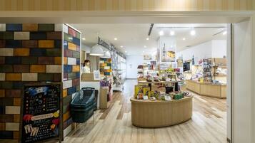 A modern interior with a wooden reception desk, a colorful brick wall, and various items on display.