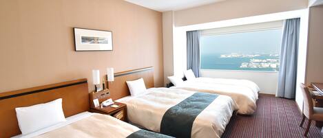 A hotel room with two beds, a desk, a chair, a nightstand, a lamp, a phone, a picture on the wall, and a large window with a view of the city.