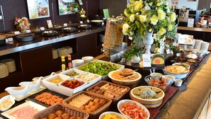 A buffet with various food items and a flower arrangement. - Star Gate Hotel Kansai Airport (Izumisano)