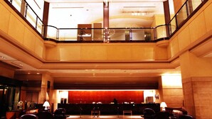 A hotel lobby with a reception desk, seating area, and a glass railing overlooking the lower level. - Star Gate Hotel Kansai Airport (Izumisano)