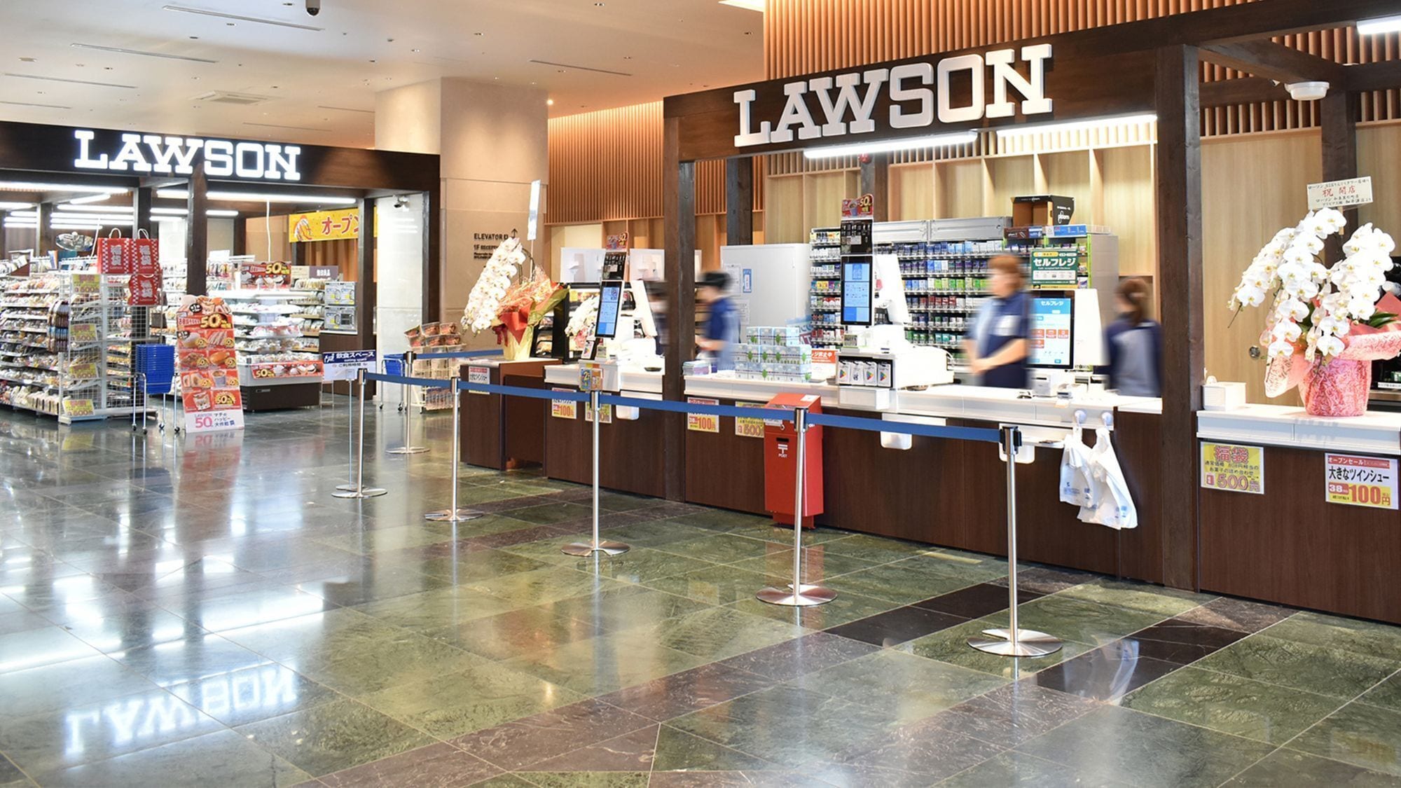 A Lawson convenience store with a clean, tiled floor and a wooden counter.