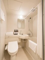 Un baño moderno con inodoro, lavamanos, espejo, ducha y toallero.