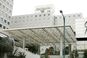 A modern hotel with a prominent entrance and a covered walkway.