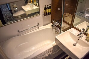 A modern bathroom with a bathtub, a sink, and a mirror.