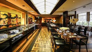 A hotel dining area with a long table, chairs, and a patterned floor. - New Otani Inn Tokyo (Tokyo)