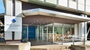 The exterior of Hotel Mystays in Yokohama, featuring a modern design with a glass entrance and a prominent sign. - Hotel MyStays Yokohama (Yokohama)