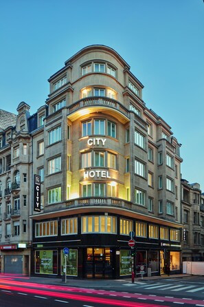 UN HÔTEL URBAIN doté d’une enseigne bien visible, de grandes fenêtres et d’une façade moderne.