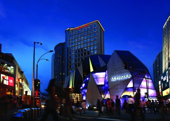 A modern building with a prominent Sephora sign, surrounded by urban skyscrapers and busy street activity.