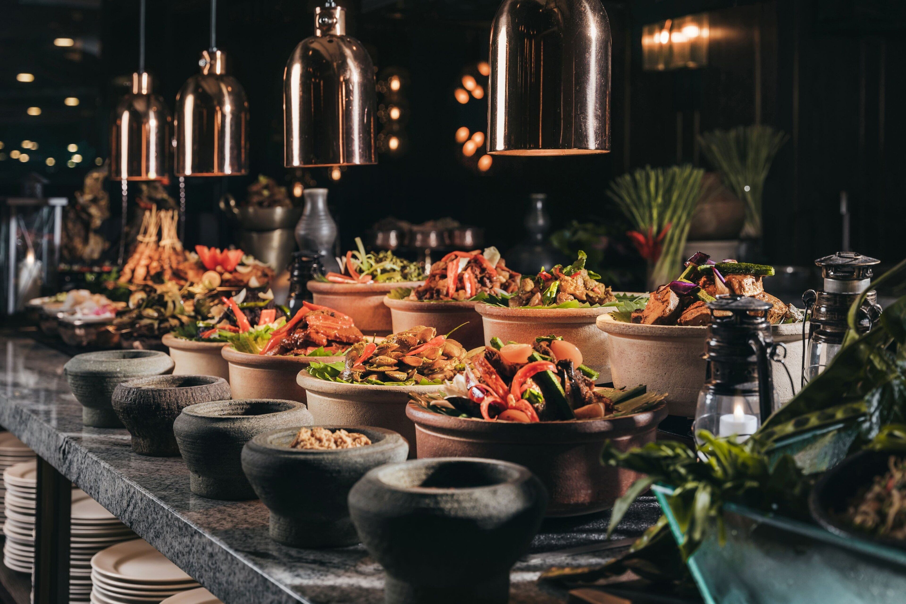 A buffet with various dishes and a selection of bowls and plates.