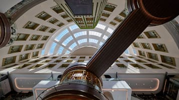 A spacious atrium with a high ceiling, multiple balconies, and a central column.