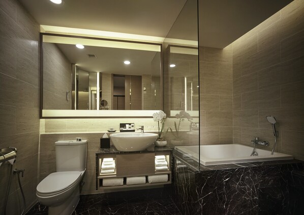 Un baño moderno con inodoro, lavamanos y bañera.