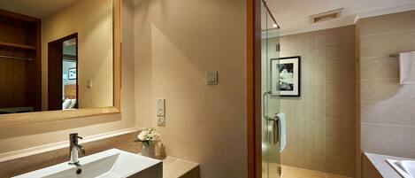 Un baño moderno con un espejo grande, un lavabo y una zona de ducha.