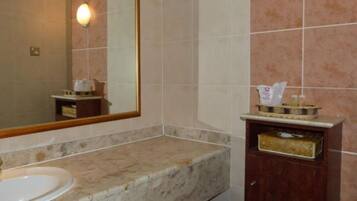 A bathroom with a sink, mirror, and toiletries.