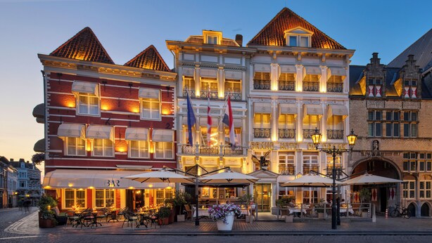 A historic hotel with multiple stories, large windows, and a classic European architectural style.