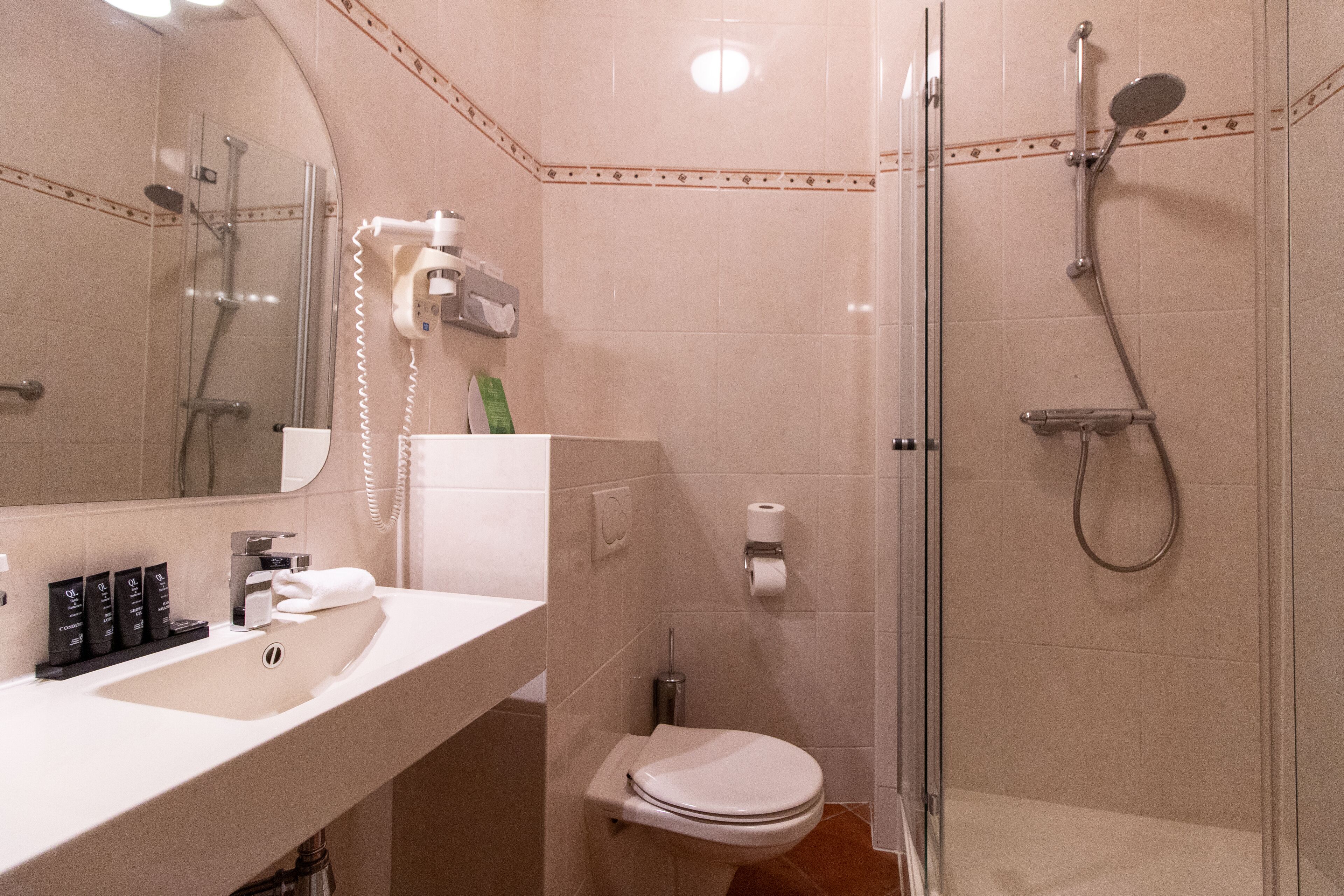A bathroom with a sink, toilet, and shower.