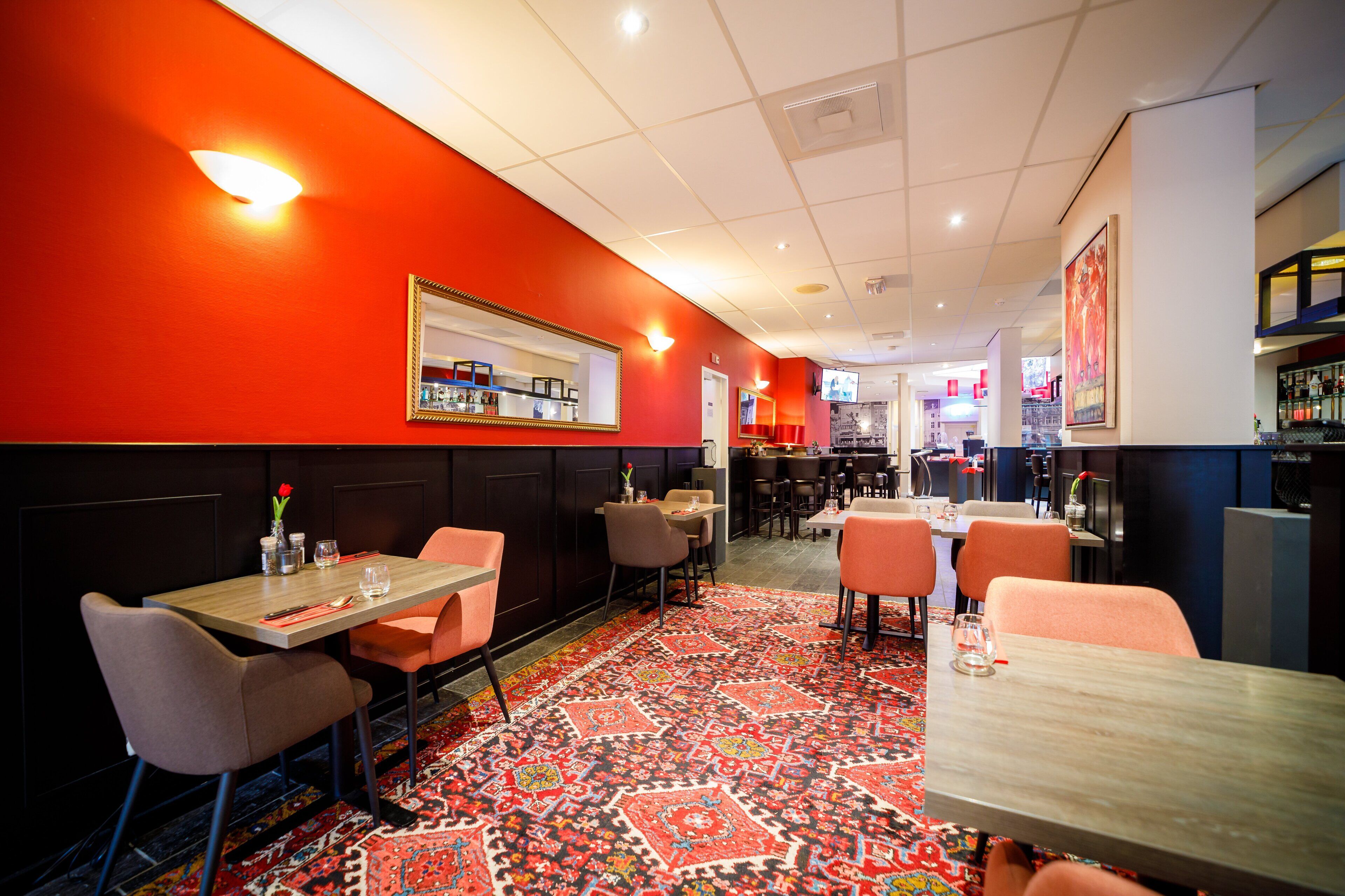 A restaurant interior with booths, tables, and a patterned carpet.