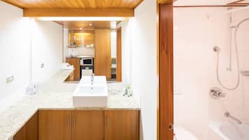 Un baño moderno con tocador de madera, un espejo grande y una zona de ducha separada.