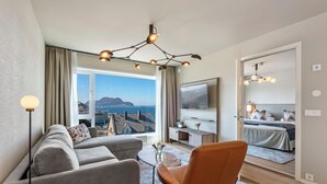 Un salon moderne avec un canapé, une table basse et une vue sur la mer.